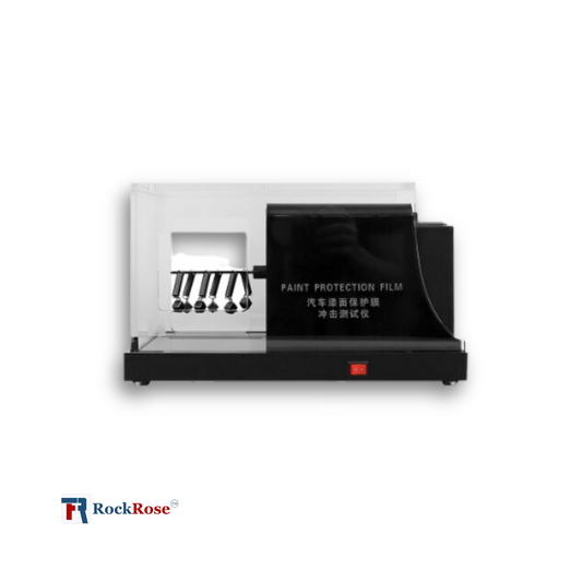 A Paint Protection Film Scratch Test Device with a white body, black scratch test panels, and red control buttons.