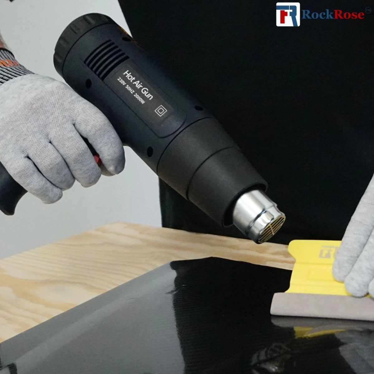 Hot air gun being used on a wooden surface with RockRose branding.