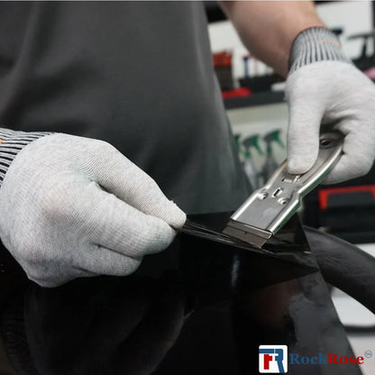Person wearing gloves using a Steel Razor Scraper  to a car's bodywork, with Rock Rose logo visible.