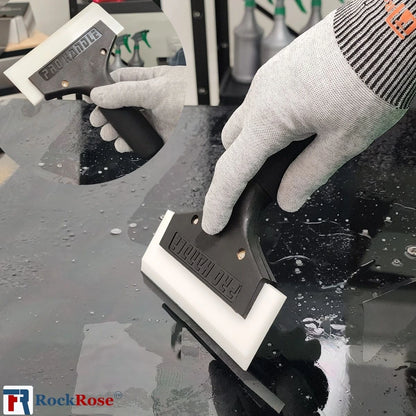 Black Cast aluminum squeegee with white tint scraper on a black surface
