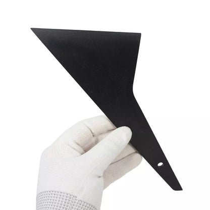 Black triangle tool held by a gloved hand on a white background