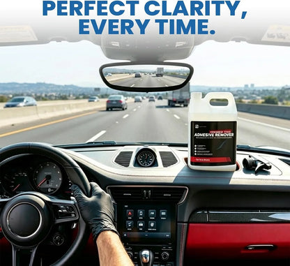 Car interior with a bottle of adhesive remover on the dashboard, highway in the background.