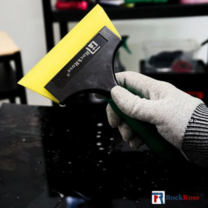 Holding a green squeegee using a glove with yellow tint scrapper and rockrose logo 