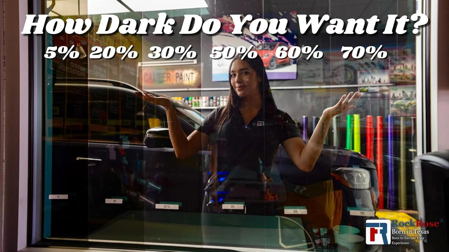 Person in a car tint shop with VLT color  selections for car tint