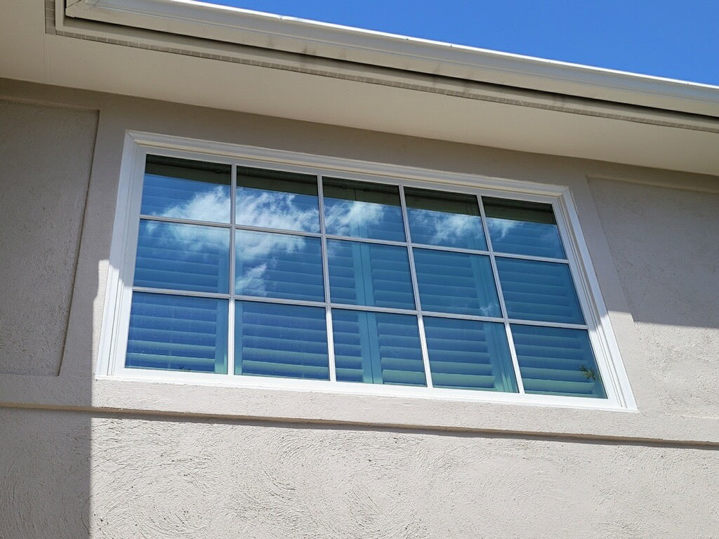 Window tint with blue shutters on a house exterior