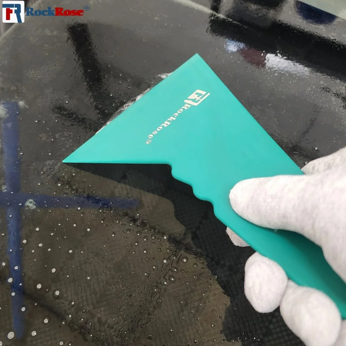 Person using a Quick Foot Squeegee – Green window cleaning tool on a glass surface with RockRose logo.