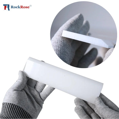 White plastic strip held by a gloved hand with a close-up inset showing texture details.