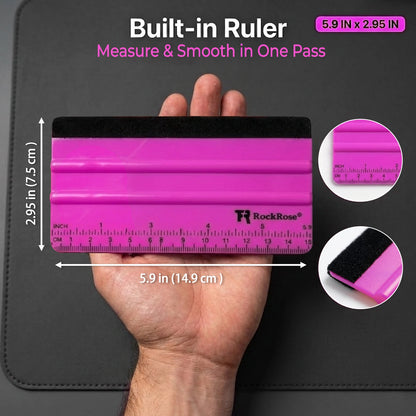 A RockRose built-in ruler held in a hand, showing a bright pink and black plastic tool with printed measurement markings. The image includes text reading 'Built-in Ruler' and dimensions, plus two circular close-up insets highlighting the ruler surface and the black rubber edge.