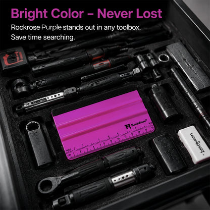 A black tool organizer tray holding multiple black hand tools and accessories, with a bright pink Rockrose ruler and matching pink storage piece centered in the tray. Text at the top reads 'Bright Color - Never Lost' and 'Rockrose Purple stands out in any toolbox.
