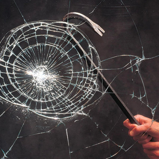 Hand holding a crowbar against a shattered glass window