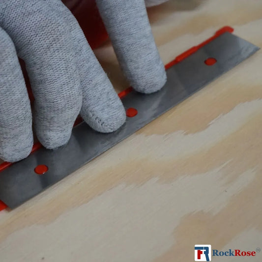 Person using a Stainless Steel Double-Edge Razor Blades tool on a wooden surface with 'RockRose' branding.