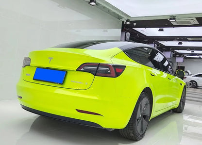 Lime green Tesla car in a showroom setting 