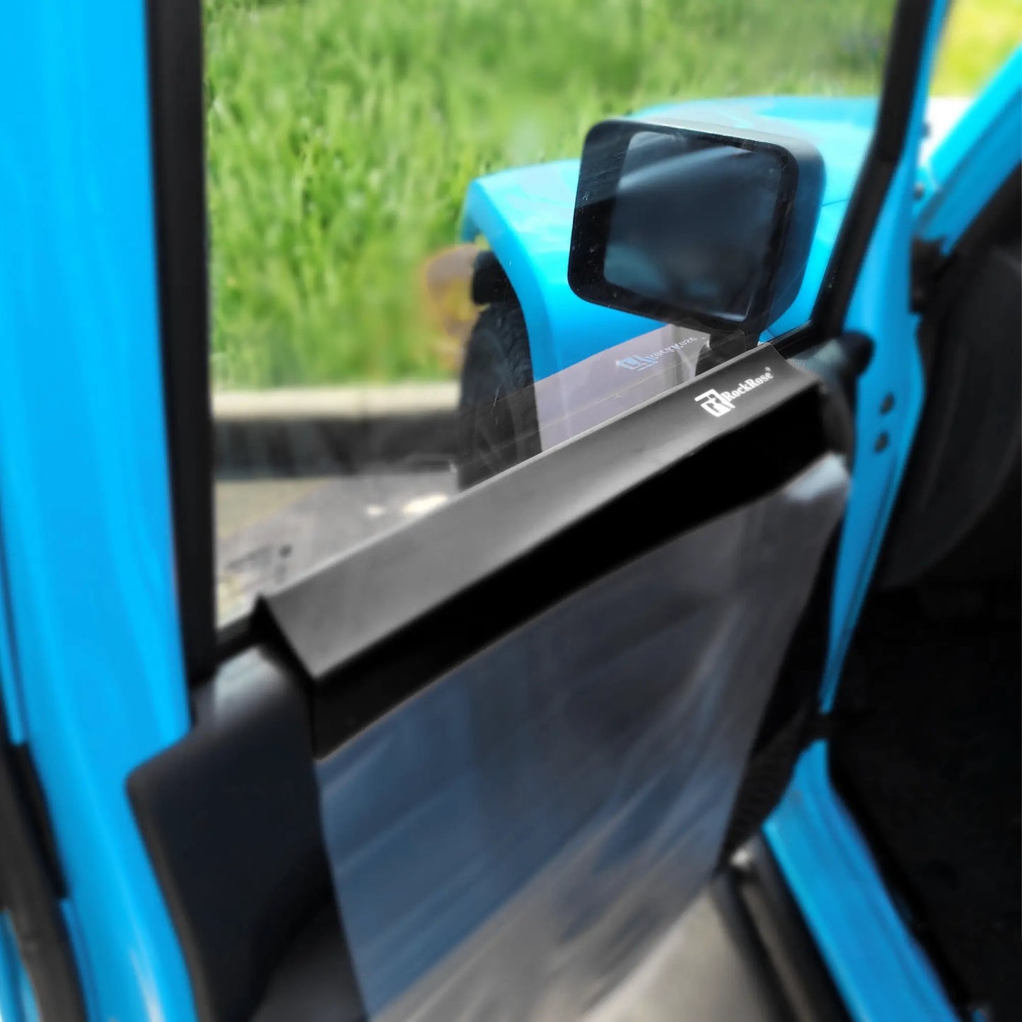 Close-up of a blue vehicle door with a side mirror and side mirror on green grass background