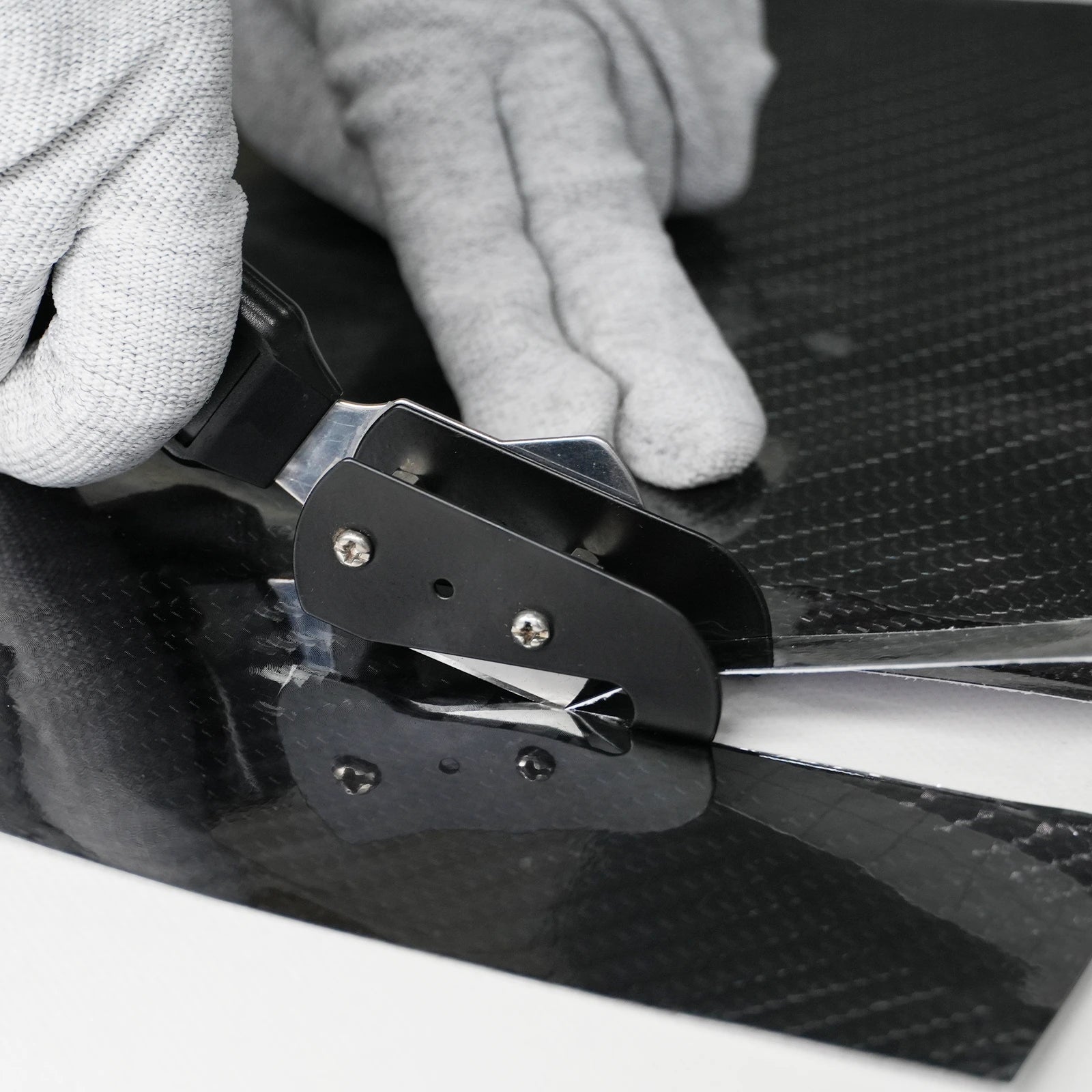 Person using a car window cutter tool removal tool on a car window.