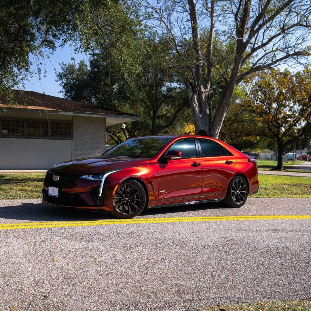 lincoln cherry red metallic car with yellow lines and trees