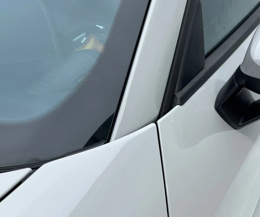 Close-up of a car door with a side mirror on a white vehicle